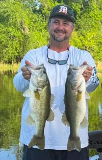 Bass Team Coach Travis Page holding two 4-pound bass at Lake Seminole