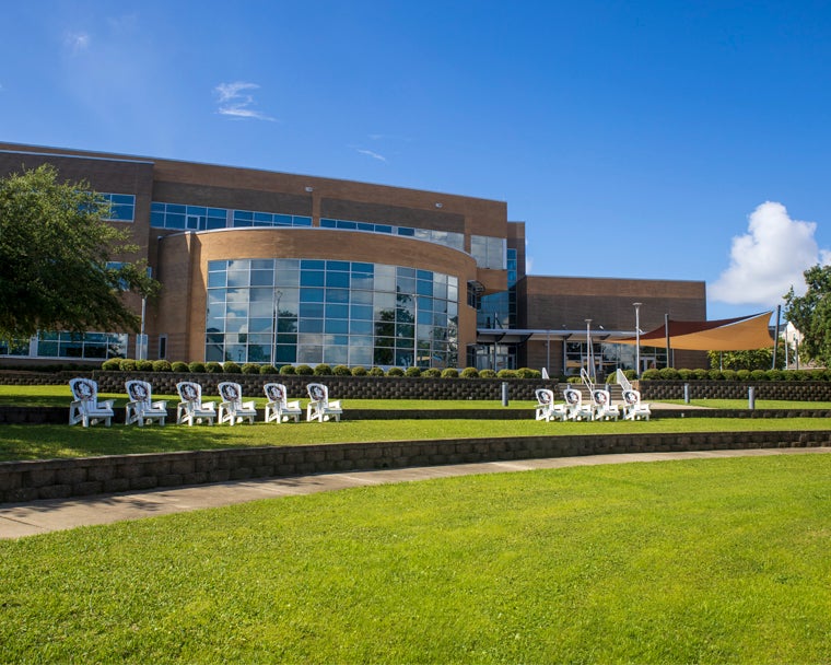 Back of the Holley Academic Center with Nole chairs on a sunny day with blue skies