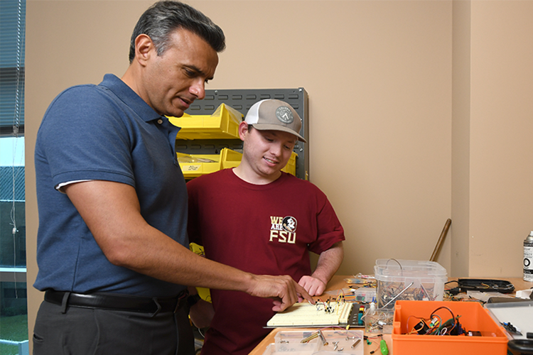 Dr. Damion Dunlap talking with a student