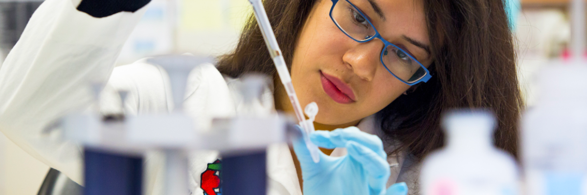 woman holding a pipette to a glass