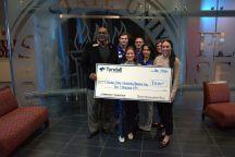 Several people holding oversized check for photo purposes