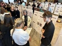 Judges speaking with students at Student Research Symposium