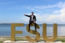 Brent Cerney sitting atop the FSU letters by the bay.