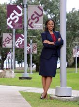 Female student leaning against post