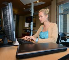 Female student at computer station in library