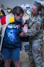 Senior Master Sergeant Lindsay Rickert helps student get into 80 lb bomb suit