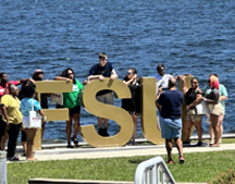 Guests around the FSU letters by the bay