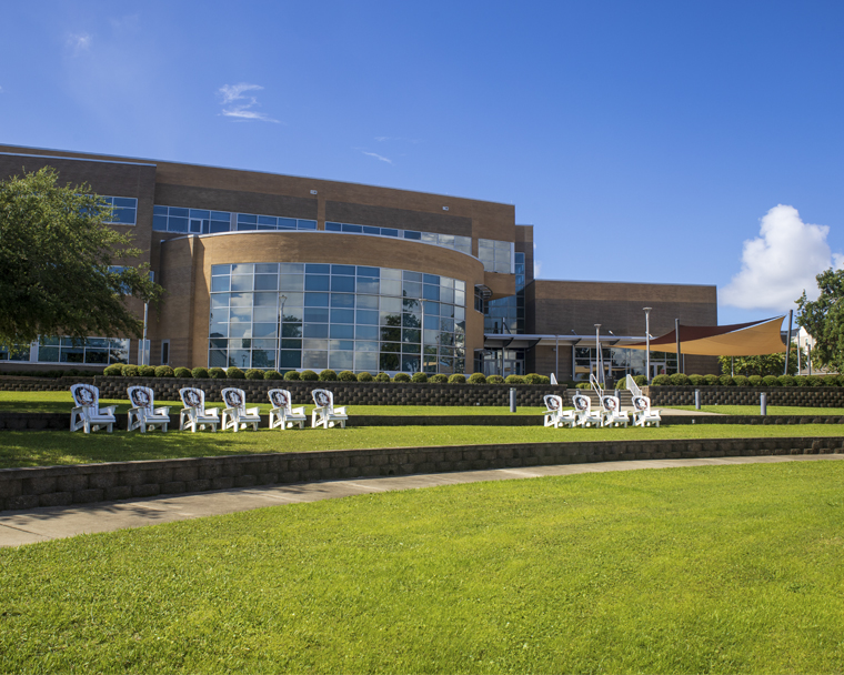 Back of the Holley Academic Center with Nole chairs on a sunny day with blue skies