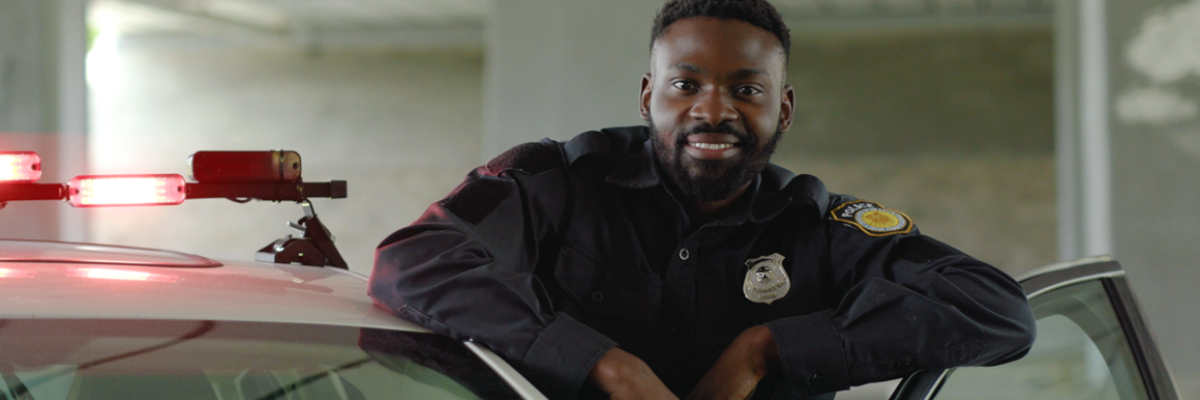 smiling cop standing with car door open
