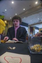 Student robed, then signs Freshmen Book