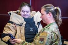 Senior Master Sergeant Lindsay Rickert helps student get into 80 lb bomb suit