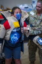 Senior Master Sergeant Lindsay Rickert helps student get into 80 lb bomb suit