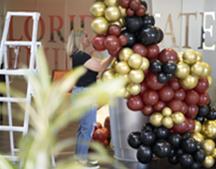 FSU PC grad Brittany Infinger, '10, adjusts her garnet and gold balloon arch.