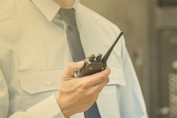 uniformed professional holding handheld radio