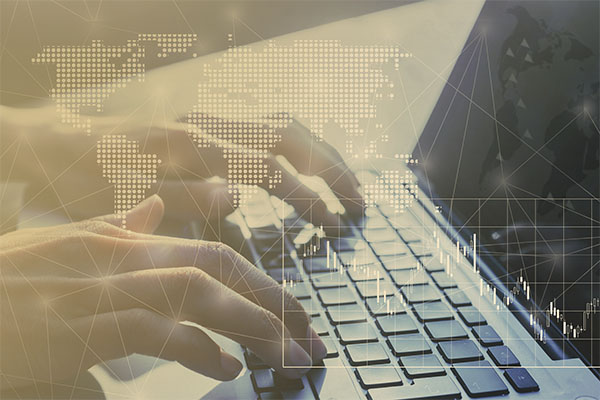 hands typing on laptop with world map graphic overlay
