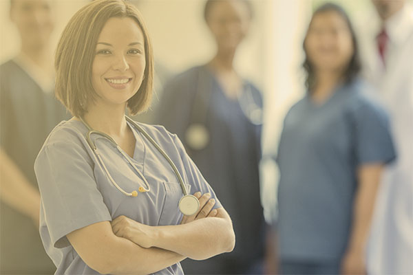 clinician in scrubs with stethoscope around neck