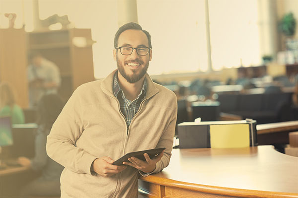 smiling librarian in front of circulation desk