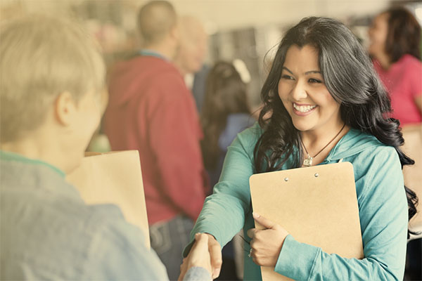 social worker with clipboard shaking hands