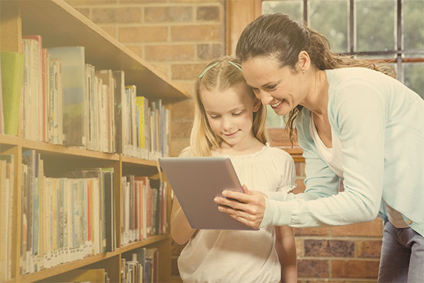 librarian showing book to young child in a library