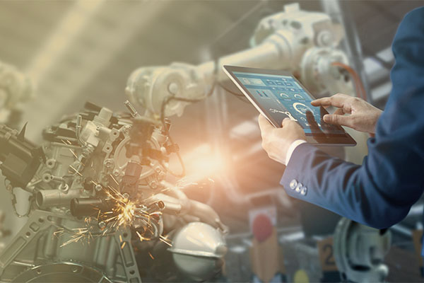 engineer using tablet computer to control robotic equipment